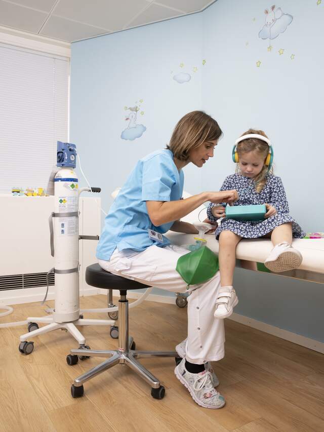 Une infirmière qui joue avec une enfant pour la détendre